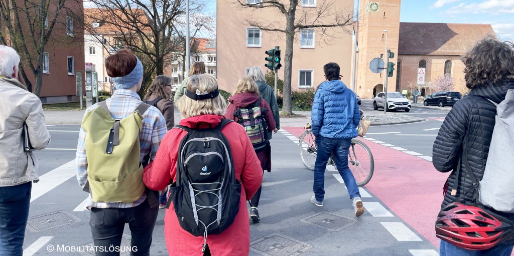 Foto von Teilnehmende der Begehung, die eine Straße an einer Ampel queren.
